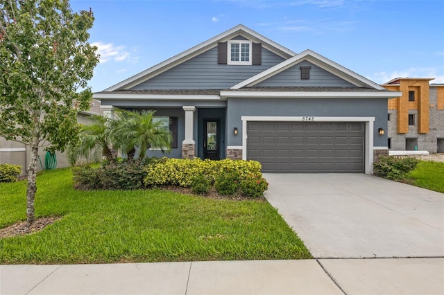 5742 Stockport St, Riverview, FL 33578 - view of front facade with a garage, a front lawn, driveway, and stone siding