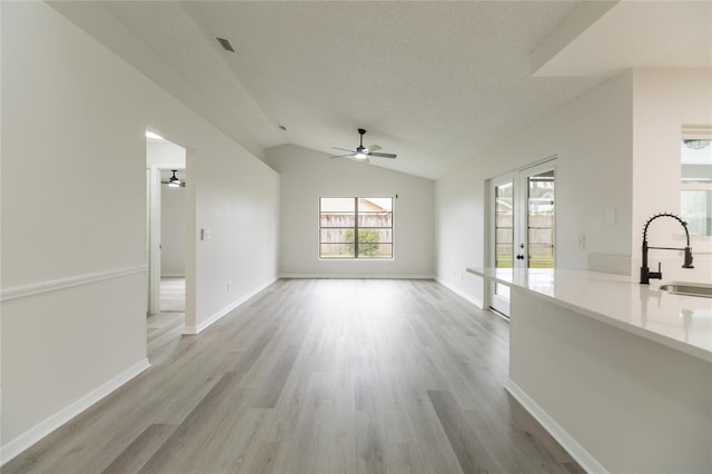 1209 Sugar Creek Ln, Rockledge, FL 32955 - unfurnished living room featuring a ceiling fan, a sink, light wood-type flooring, french doors, and vaulted ceiling