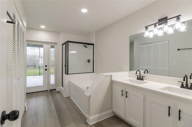 1209 Sugar Creek Ln, Rockledge, FL 32955 - bathroom with a garden tub, double vanity, a stall shower, wood finished floors, and recessed lighting