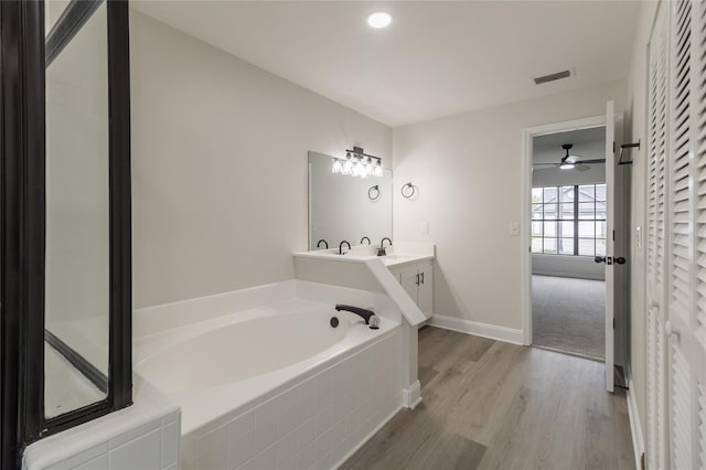 1209 Sugar Creek Ln, Rockledge, FL 32955 - full bathroom featuring a garden tub, vanity, wood finished floors, a ceiling fan, and baseboards