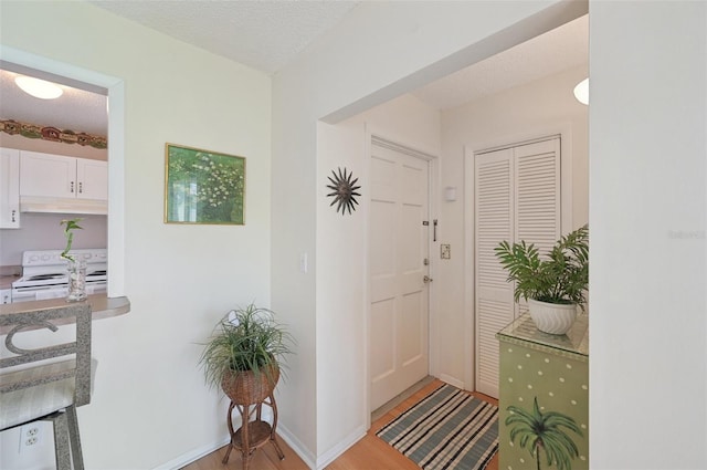 7304 W Country Club Dr N Unit 113, Sarasota, FL 34243 - entrance foyer featuring light wood finished floors, a textured ceiling, and baseboards