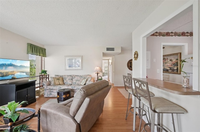 7304 W Country Club Dr N Unit 113, Sarasota, FL 34243 - living room featuring a textured ceiling and light wood finished floors
