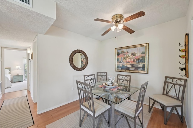7304 W Country Club Dr N Unit 113, Sarasota, FL 34243 - dining area with a textured ceiling, light wood finished floors, ceiling fan, and baseboards