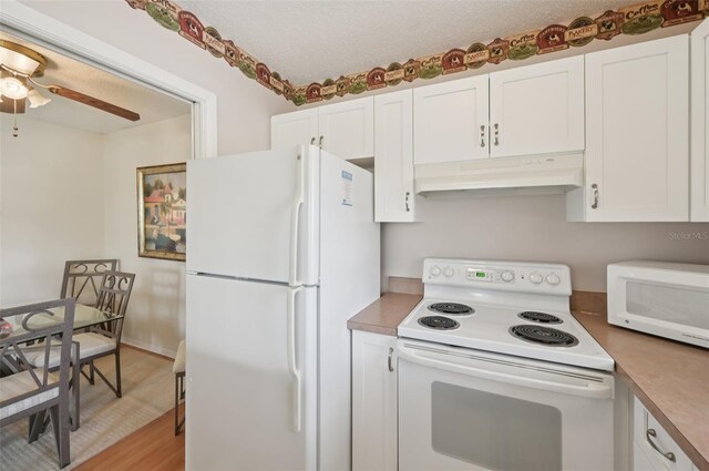 7304 W Country Club Dr N Unit 113, Sarasota, FL 34243 - kitchen featuring white appliances, extractor fan, white cabinetry, a ceiling fan, and a textured ceiling