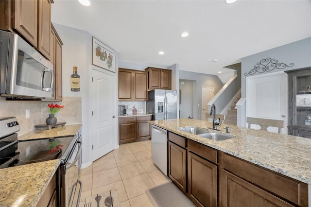 5624 Fisher Glen Loop, Wesley Chapel, FL 33545 - kitchen with stainless steel appliances, a sink, backsplash, light tile patterned flooring, and light stone countertops