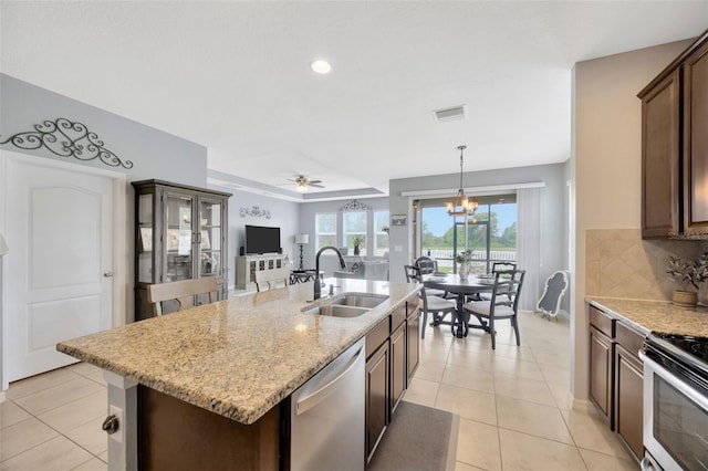 5624 Fisher Glen Loop, Wesley Chapel, FL 33545 - kitchen featuring a sink, stainless steel appliances, tasteful backsplash, an island with sink, and light tile patterned floors