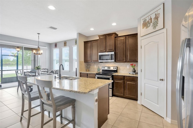 5624 Fisher Glen Loop, Wesley Chapel, FL 33545 - kitchen with appliances with stainless steel finishes, a sink, backsplash, a breakfast bar area, and an island with sink