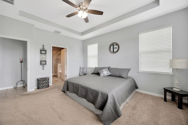 5624 Fisher Glen Loop, Wesley Chapel, FL 33545 - carpeted bedroom featuring a raised ceiling, baseboards, ensuite bathroom, and a ceiling fan