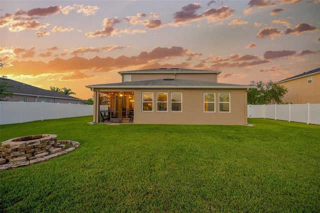 5624 Fisher Glen Loop, Wesley Chapel, FL 33545 - back of house at dusk with a fire pit, a sunroom, and stucco siding