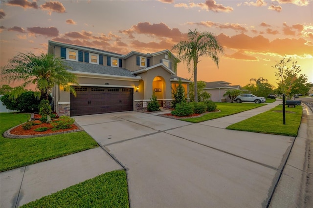 5624 Fisher Glen Loop, Wesley Chapel, FL 33545 - view of front of house with stone siding, stucco siding, concrete driveway, a lawn, and an attached garage