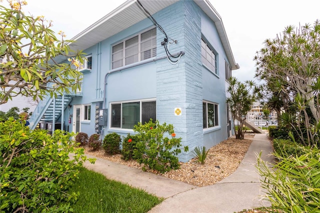 241 Skiff Pt Unit 1, Clearwater Beach, FL 33767 - view of property exterior featuring stairs and stucco siding