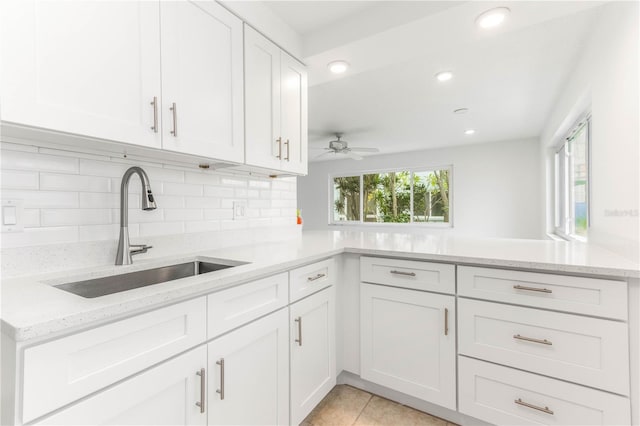 241 Skiff Pt Unit 1, Clearwater Beach, FL 33767 - kitchen featuring a sink, light stone countertops, white cabinets, backsplash, and recessed lighting
