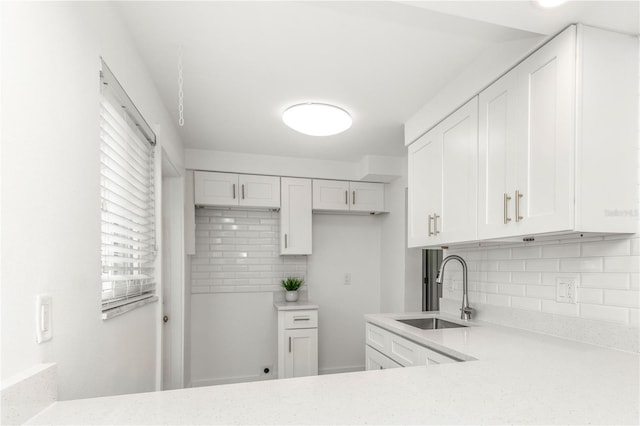 241 Skiff Pt Unit 1, Clearwater Beach, FL 33767 - kitchen with a sink, backsplash, white cabinets, and light stone counters