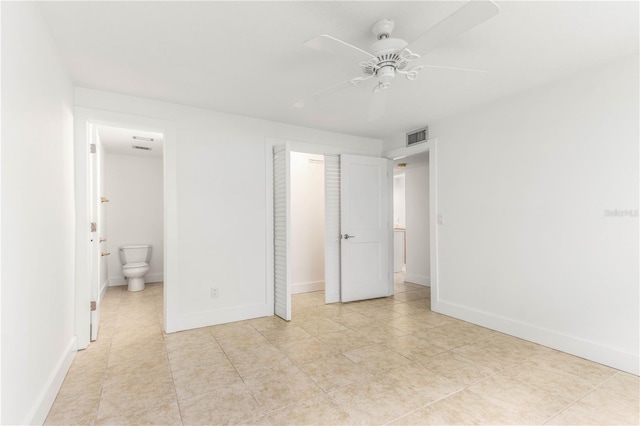 241 Skiff Pt Unit 1, Clearwater Beach, FL 33767 - unfurnished bedroom with a closet, light tile patterned floors, baseboards, ensuite bath, and ceiling fan