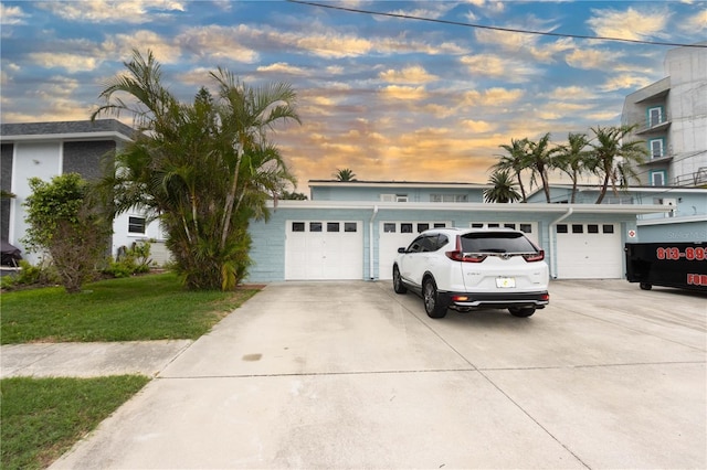 241 Skiff Pt Unit 1, Clearwater Beach, FL 33767 - view of front of home with concrete driveway, a front lawn, and an attached garage