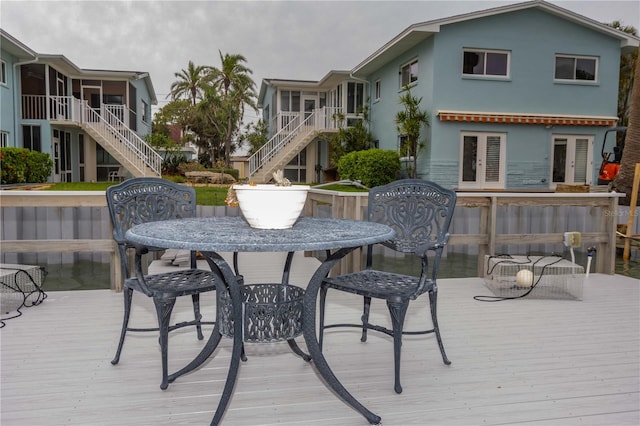 241 Skiff Pt Unit 1, Clearwater Beach, FL 33767 - wooden terrace with stairs, outdoor dining area, a sunroom, and french doors