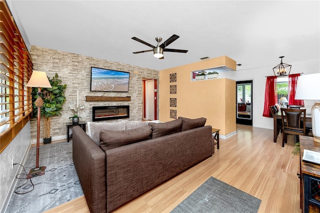 614 12th St NW, Largo, FL 33770 - living area featuring a fireplace, a ceiling fan, wood finished floors, and a chandelier