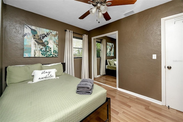 614 12th St NW, Largo, FL 33770 - bedroom featuring a textured wall, light wood finished floors, and a ceiling fan