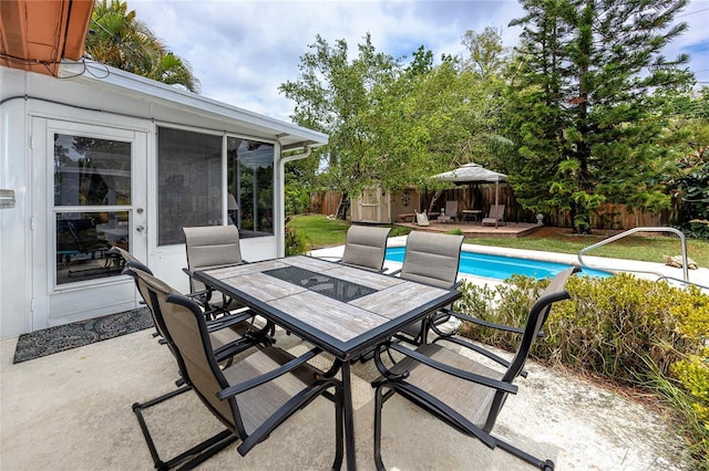 614 12th St NW, Largo, FL 33770 - fenced backyard featuring outdoor dining area, a patio area, a storage shed, and a sunroom