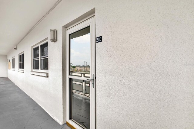 5501 80th St N Unit 206, Saint Petersburg, FL 33709 - doorway to property featuring stucco siding and a balcony