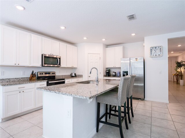 573 Vista Villages Blvd, Davenport, FL 33896 - kitchen with stainless steel appliances, a sink, light tile patterned floors, white cabinetry, and recessed lighting