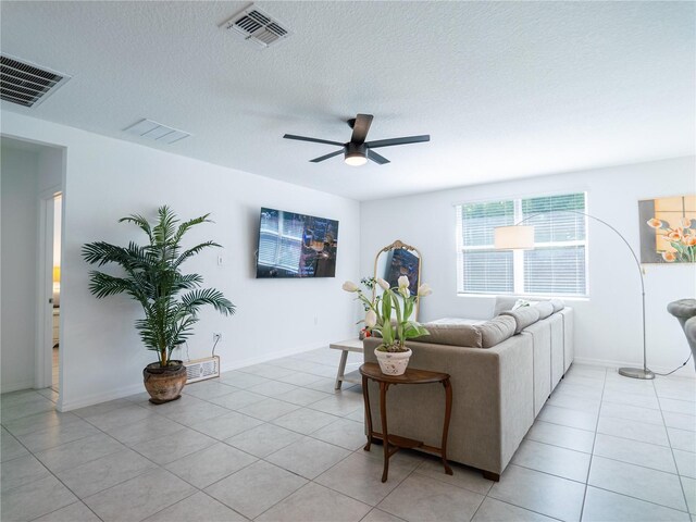 573 Vista Villages Blvd, Davenport, FL 33896 - living area with a ceiling fan, light tile patterned floors, a textured ceiling, and baseboards