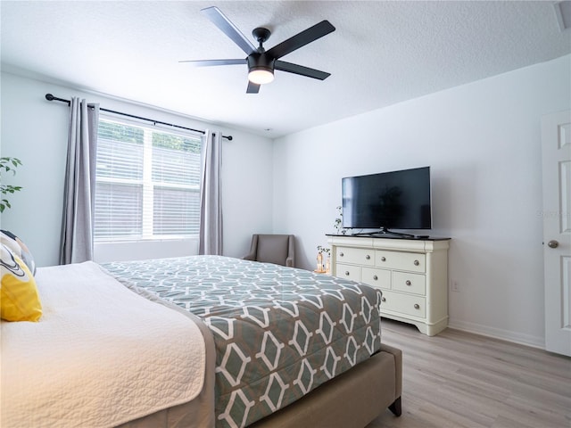 573 Vista Villages Blvd, Davenport, FL 33896 - bedroom with light wood-type flooring, baseboards, ceiling fan, and a textured ceiling