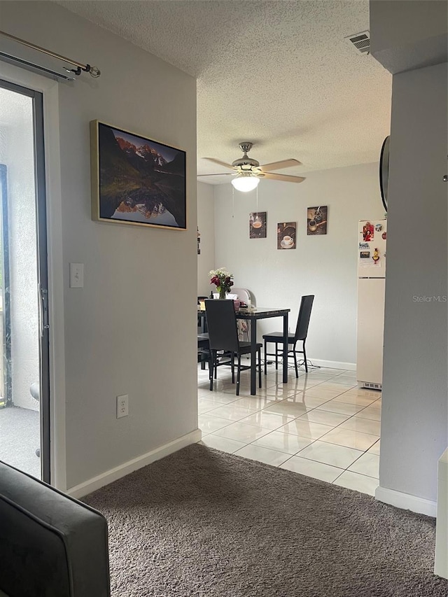 3802 Cortez Cir Unit D, Tampa, FL 33614 - dining space featuring ceiling fan, a textured ceiling, light carpet, light tile patterned floors, and baseboards