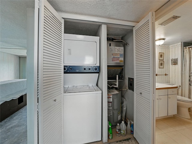 7600 Sun Island Dr S Unit 603, South Pasadena, FL 33707 - washroom with stacked washer / drying machine, a textured ceiling, and light tile patterned floors