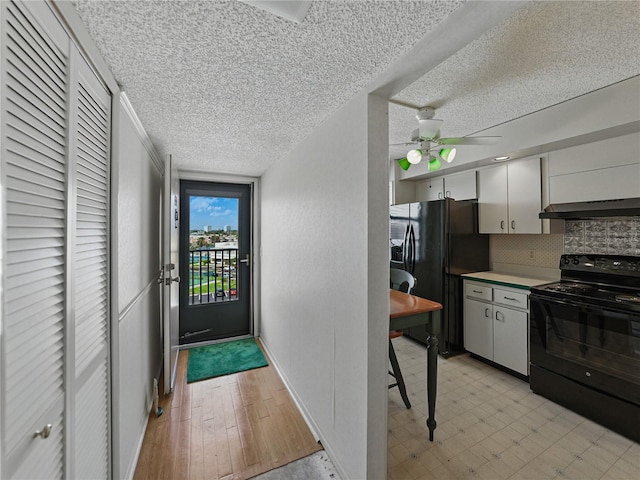 7600 Sun Island Dr S Unit 603, South Pasadena, FL 33707 - kitchen with black appliances, under cabinet range hood, ceiling fan, tasteful backsplash, and a textured ceiling