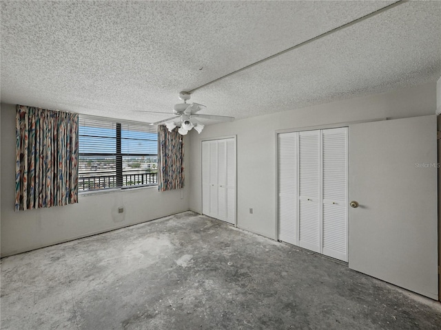 7600 Sun Island Dr S Unit 603, South Pasadena, FL 33707 - unfurnished bedroom with two closets, a textured ceiling, concrete flooring, and a ceiling fan