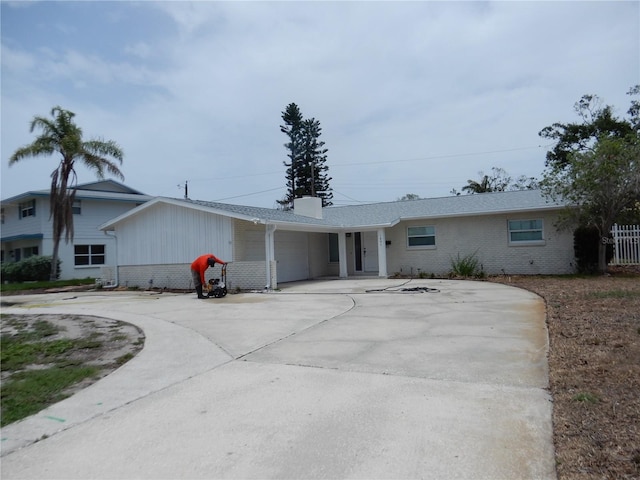 1897 Dolphin Blvd S, Saint Petersburg, FL 33707 - view of front of house featuring brick siding, a garage, a chimney, and driveway
