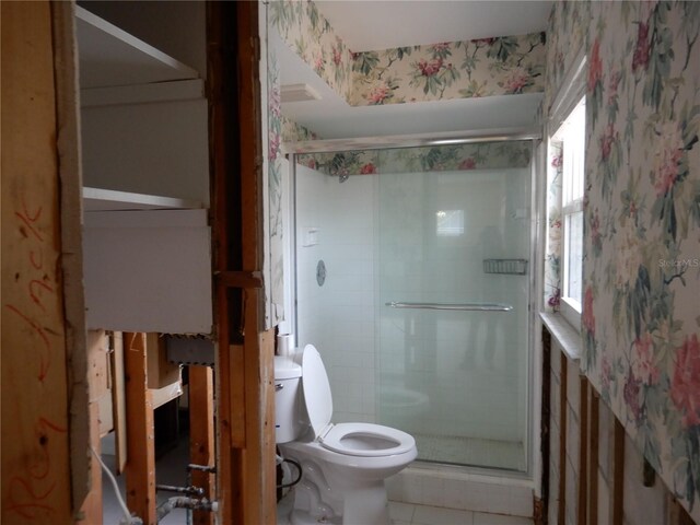 1897 Dolphin Blvd S, Saint Petersburg, FL 33707 - bathroom featuring wallpapered walls, a shower stall, toilet, and tile patterned floors