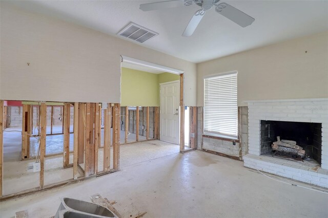1897 Dolphin Blvd S, Saint Petersburg, FL 33707 - unfurnished living room featuring ceiling fan, a brick fireplace, and concrete flooring