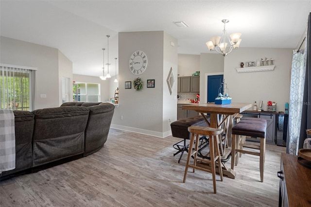 16473 Scaup Duck Ave, Weeki Wachee, FL 34614 - dining room featuring vaulted ceiling, a chandelier, light wood-style floors, and baseboards