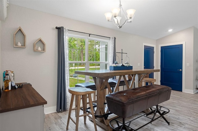 16473 Scaup Duck Ave, Weeki Wachee, FL 34614 - dining space with a chandelier, baseboards, light wood-type flooring, and vaulted ceiling