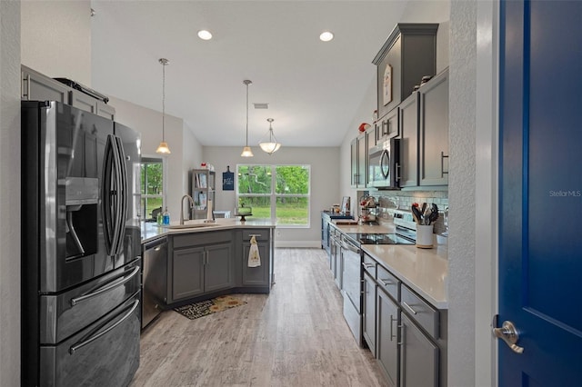 16473 Scaup Duck Ave, Weeki Wachee, FL 34614 - kitchen featuring appliances with stainless steel finishes, a sink, a peninsula, light wood-style floors, and gray cabinets