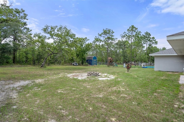 16473 Scaup Duck Ave, Weeki Wachee, FL 34614 - view of grassy yard featuring a playground and an outdoor fire pit