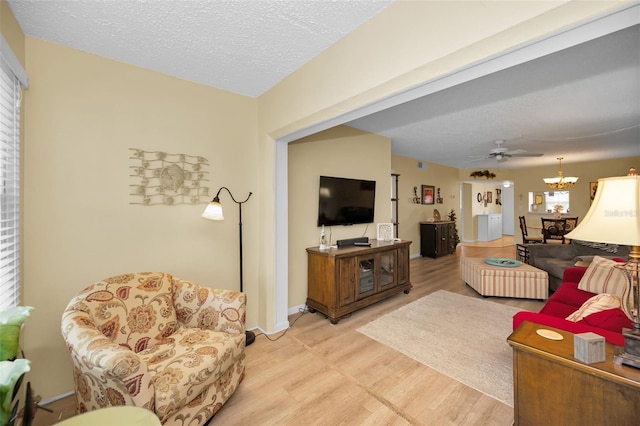 960 Virginia St Unit 202, Dunedin, FL 34698 - living area with light wood-style flooring, ceiling fan, a chandelier, and a textured ceiling