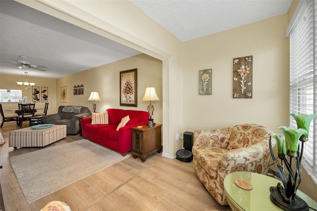 960 Virginia St Unit 202, Dunedin, FL 34698 - living room featuring light wood-style floors, a textured ceiling, healthy amount of natural light, a ceiling fan, and a chandelier