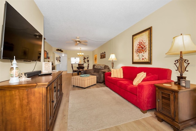 960 Virginia St Unit 202, Dunedin, FL 34698 - living area featuring light wood-style floors, a ceiling fan, a textured ceiling, and a chandelier