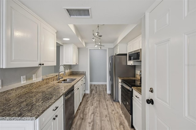 3121 Egret Ter, Safety Harbor, FL 34695 - kitchen featuring stainless steel appliances, a sink, white cabinetry, and light wood finished floors
