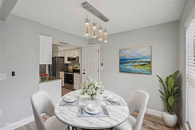 3121 Egret Ter, Safety Harbor, FL 34695 - dining area with light wood-style floors and baseboards