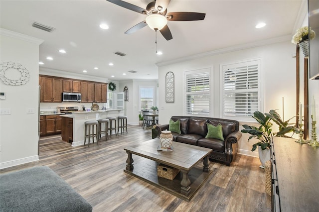 10422 Fenceline Rd, New Port Richey, FL 34655 - living room with crown molding, recessed lighting, baseboards, ceiling fan, and dark wood-style flooring