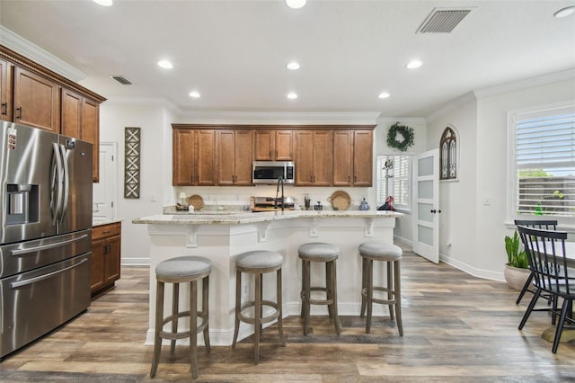 10422 Fenceline Rd, New Port Richey, FL 34655 - kitchen with appliances with stainless steel finishes, ornamental molding, a center island with sink, baseboards, and recessed lighting