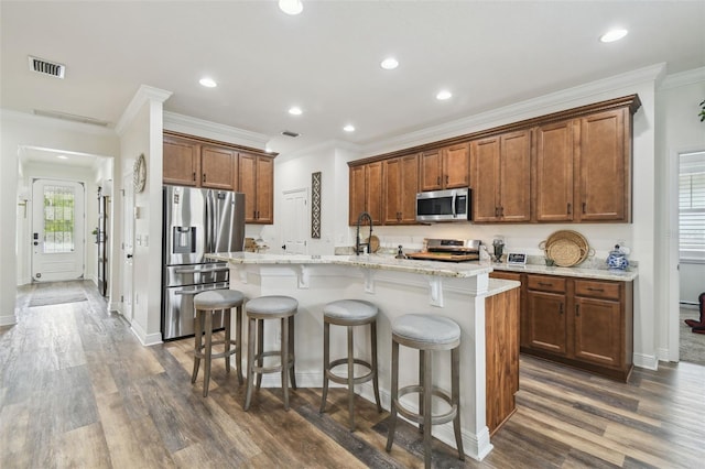 10422 Fenceline Rd, New Port Richey, FL 34655 - kitchen with appliances with stainless steel finishes, crown molding, a center island with sink, dark wood-type flooring, and recessed lighting