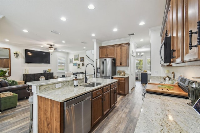 10422 Fenceline Rd, New Port Richey, FL 34655 - kitchen with appliances with stainless steel finishes, a sink, open floor plan, a kitchen bar, and ceiling fan