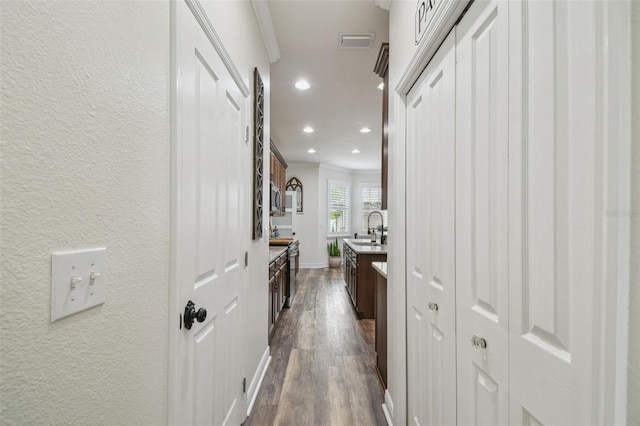 10422 Fenceline Rd, New Port Richey, FL 34655 - corridor featuring dark wood finished floors, ornamental molding, a sink, recessed lighting, and baseboards