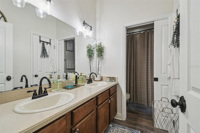 10422 Fenceline Rd, New Port Richey, FL 34655 - bathroom featuring double vanity, toilet, and wood finished floors