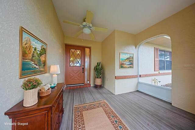 1508 Ingram Dr Unit 20, Sun City Center, FL 33573 - entrance foyer with wood finished floors, arched walkways, ceiling fan, and a textured wall